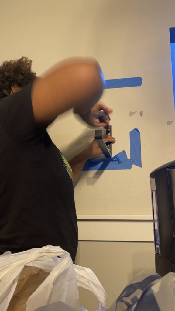 Image of Tamarah @afro and reno adding j bracket to wall for a shelf