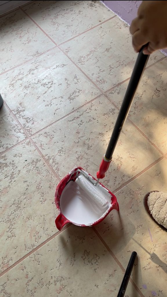 Painting aluminum patio Loading up the 6in roller with paint using a handy. paint pail